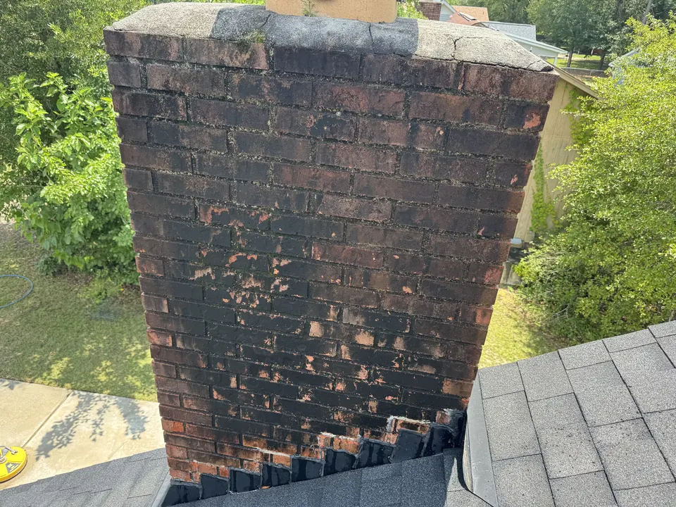 Dark, stained brick chimney before cleaning